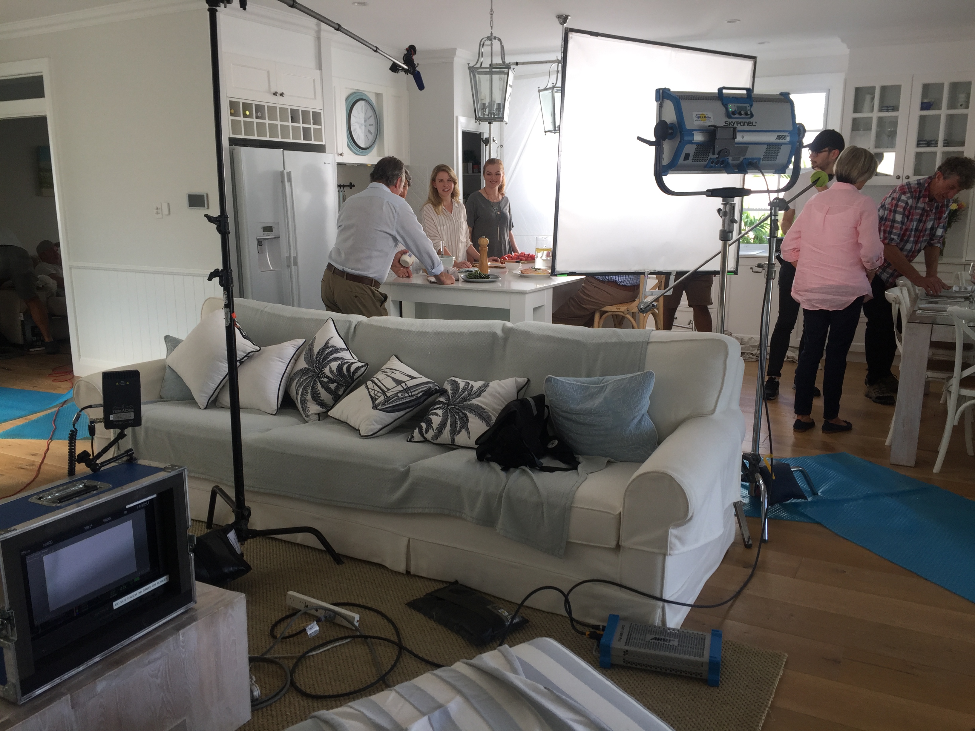 Filming of Aveo Journey campaign inside house with people standing around kitchen bench